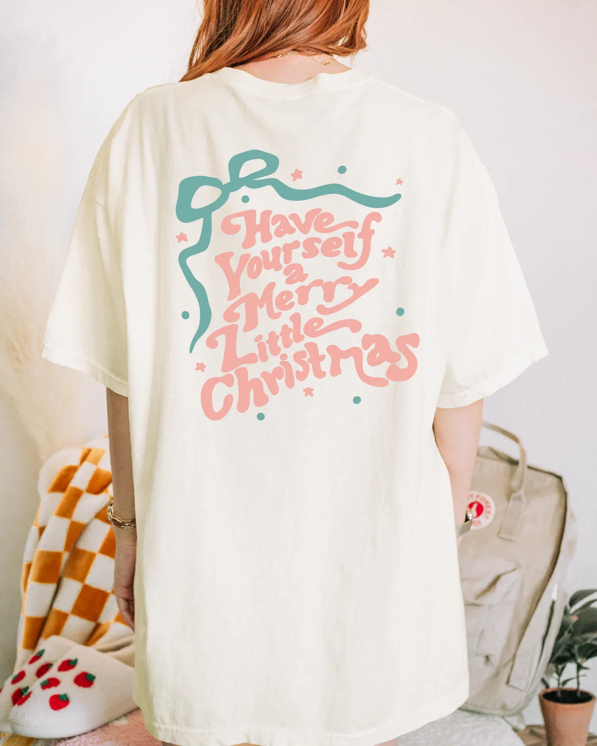 Person wearing a white t-shirt with Christmas-themed text and graphics.