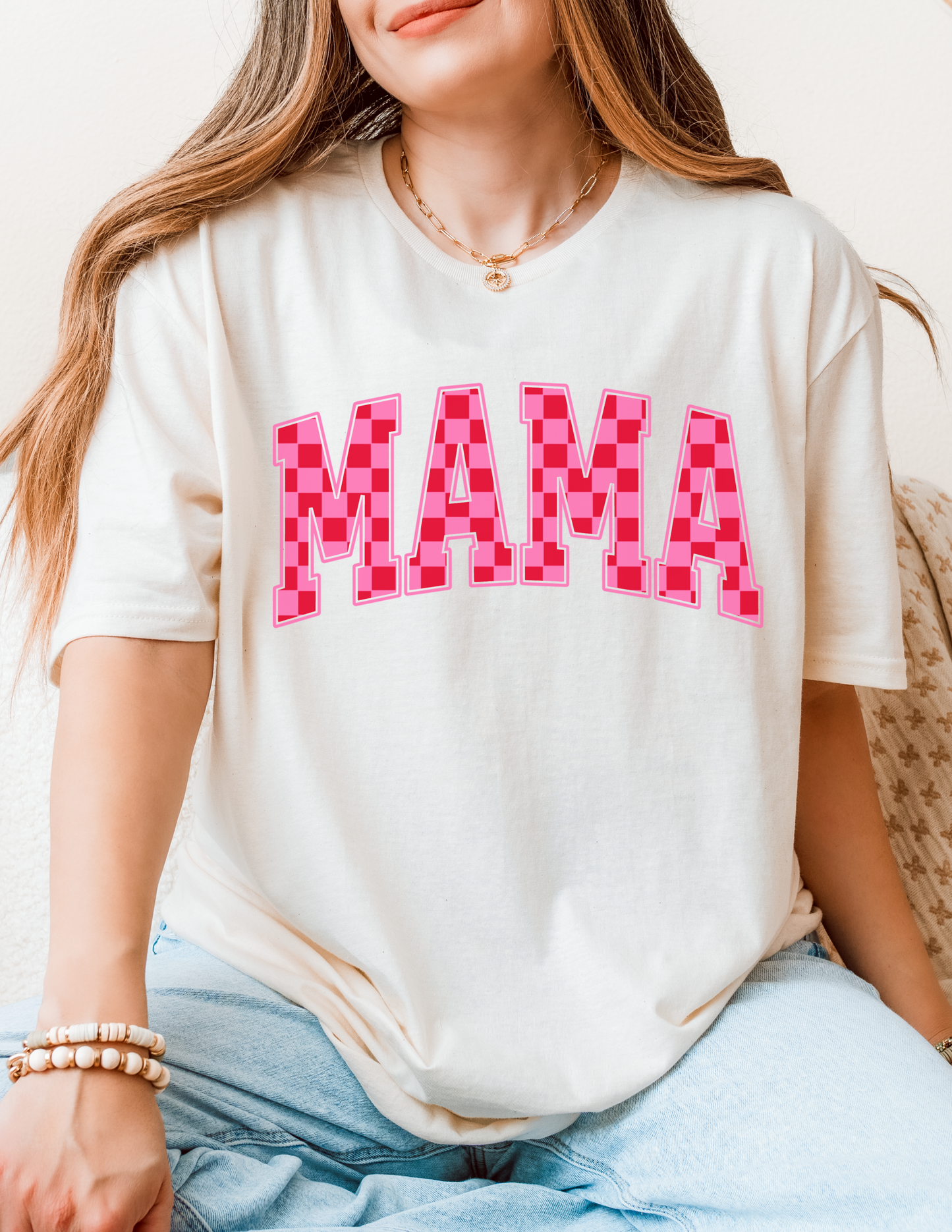 Person wearing a white t-shirt with 'MAMA' printed in pink checkered letters.