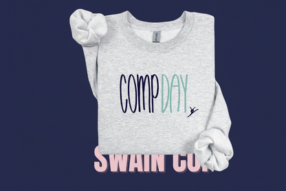 Gray sweatshirt with 'COMP DAY' text and dancer graphic on a beige background