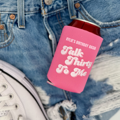 Pink can cooler with text on a denim background