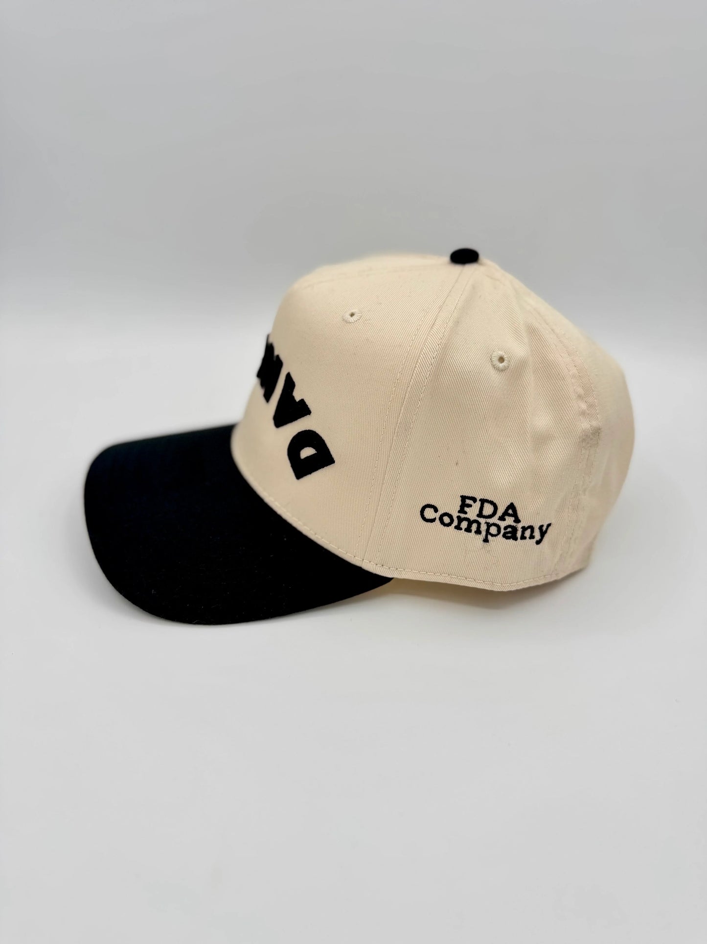 Two-tone cap with 'FDA Company' text on a light gray background. Customize for your studio