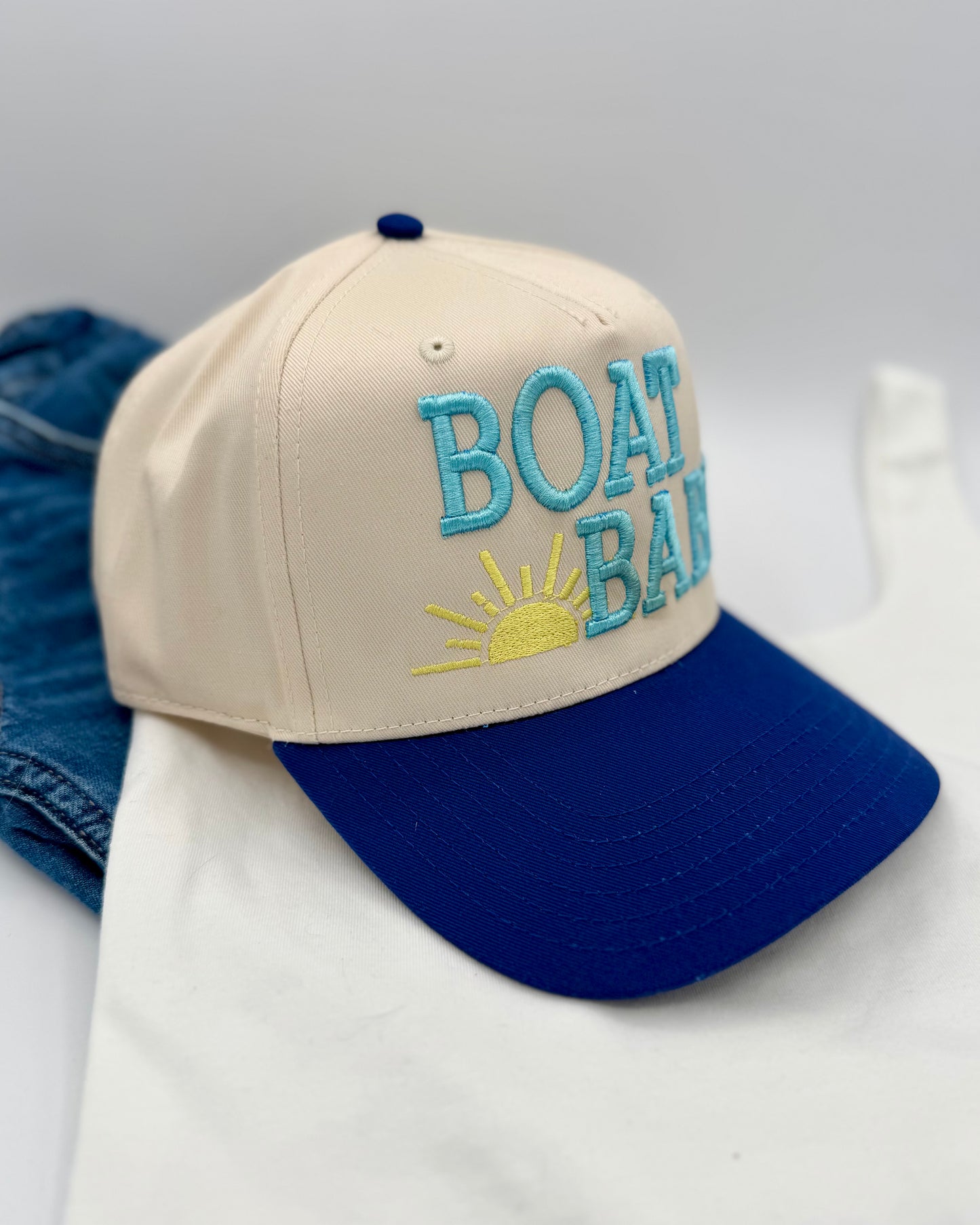 Beige and blue cap with 'BOAT BAY' text on a white background