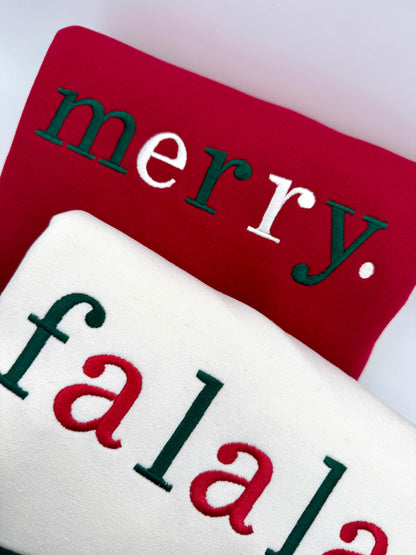 Red and white sweatshirt with 'merry' and 'falala' text on a white background