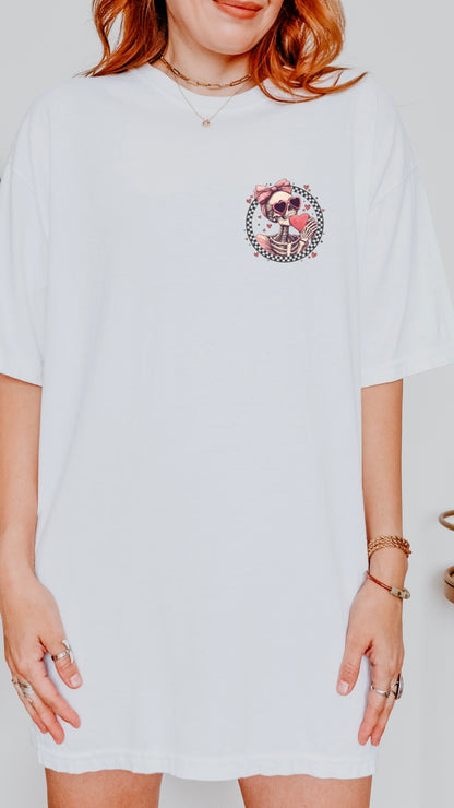 Person wearing a white t-shirt with a graphic design on a plain background
