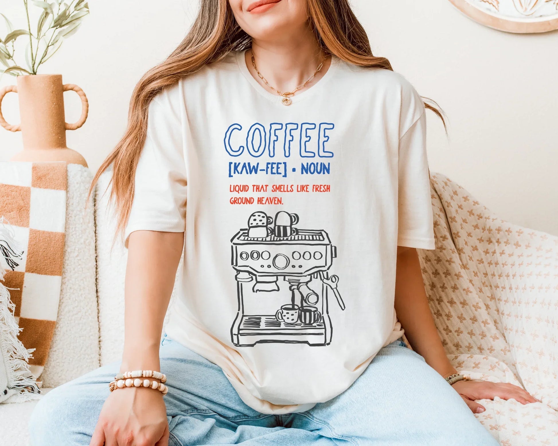 Person wearing a t-shirt with a coffee-themed design sitting on a couch.