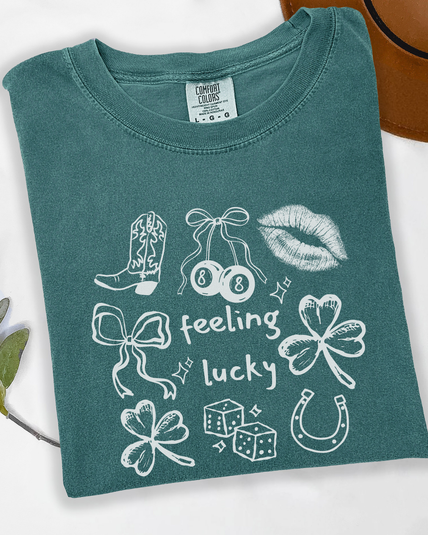 Green t-shirt with white feeling lucky graphic designs on a white background