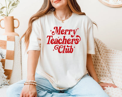Person wearing a white t-shirt with 'Merry Teachers Club' text in red, sitting on a couch.
