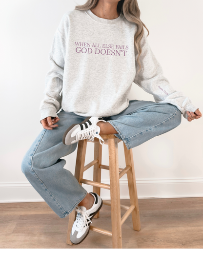 Person wearing a gray sweatshirt with text, sitting on a wooden stool.