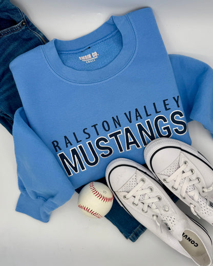 Blue sweatshirt with 'Ralston Valley Mustangs' text, white sneakers, and a baseball on a white surface.